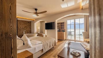 A hotel room with a bed, a desk, a TV, and a balcony with a view.