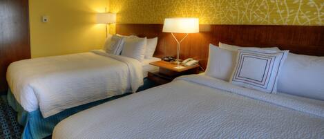 A hotel room with two beds, a nightstand with a lamp, and a patterned wall.