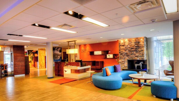A modern hotel lobby with a reception desk, seating area, and a stone accent wall. - Fairfield Inn & Suites by Marriott Princeton (Princeton)