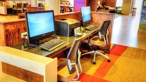 A reception area with two computer workstations, a wooden reception desk, and a colorful carpet. - Fairfield Inn & Suites by Marriott Princeton (Princeton)
