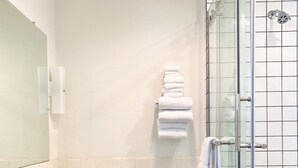 A bathroom with a toilet, sink, and glass shower enclosure.