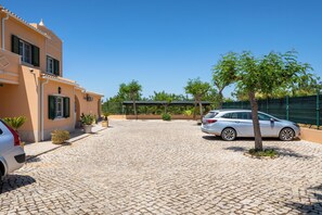 A paved driveway leading to a building with a car parked on the right. - Apartamentos Monte dos Avós, Albufeira (Albufeira)