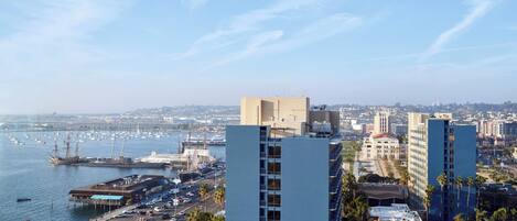 Un paisaje urbano costero con edificios modernos, un puerto deportivo y un estacionamiento.