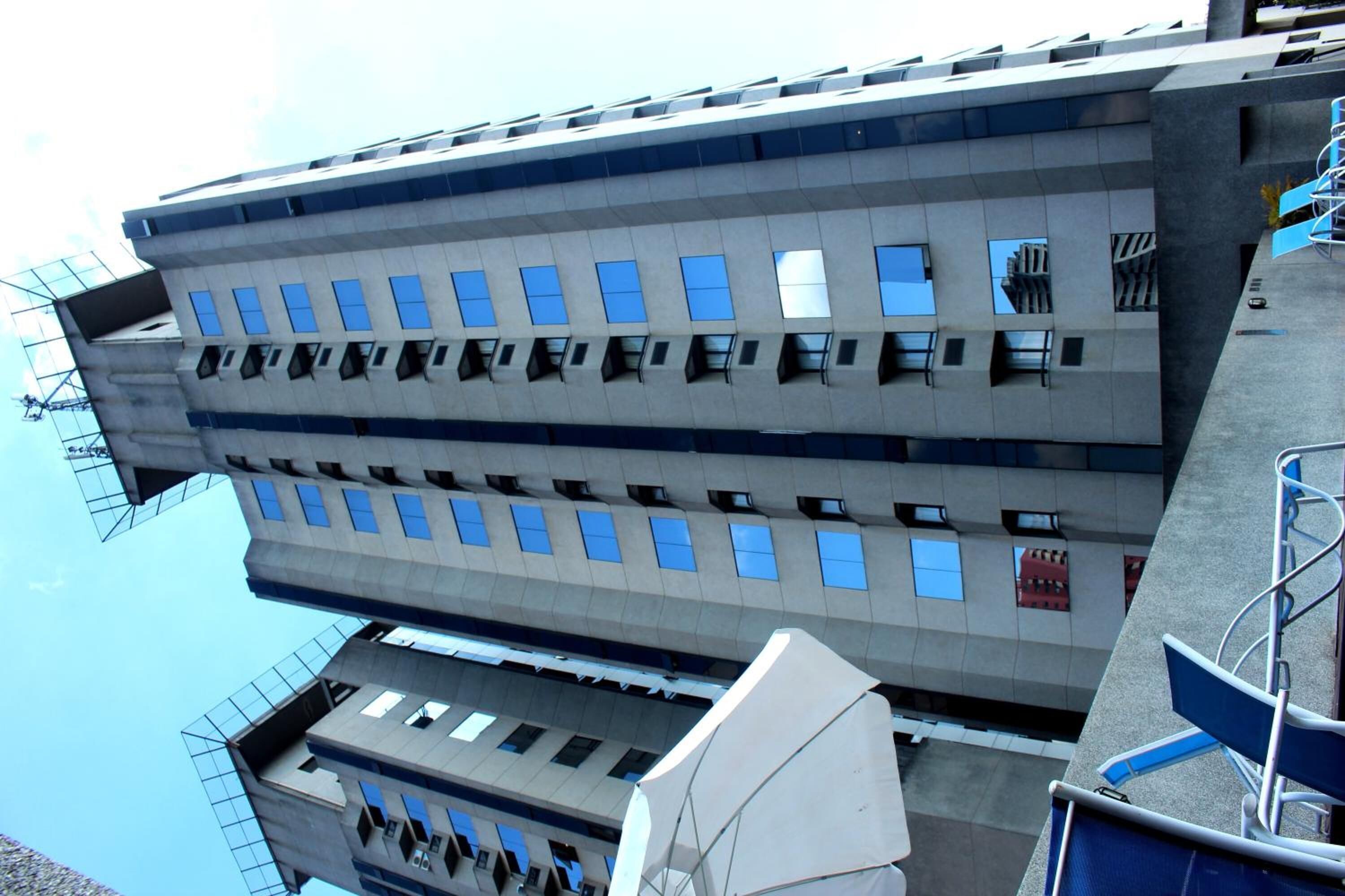 Um edifício moderno com telhado plano e várias janelas.