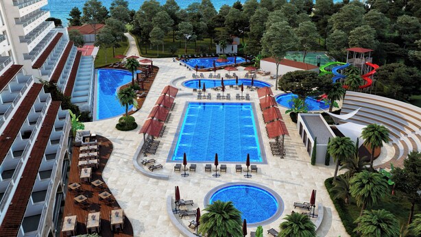 A resort with multiple swimming pools, sun loungers, and palm trees. - Batihan Beach Resort & Spa Ultra All Inclusive (Kusadasi)