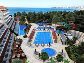 A resort with multiple swimming pools, sun loungers, and palm trees. - Batihan Beach Resort & Spa Ultra All Inclusive (Kusadasi)