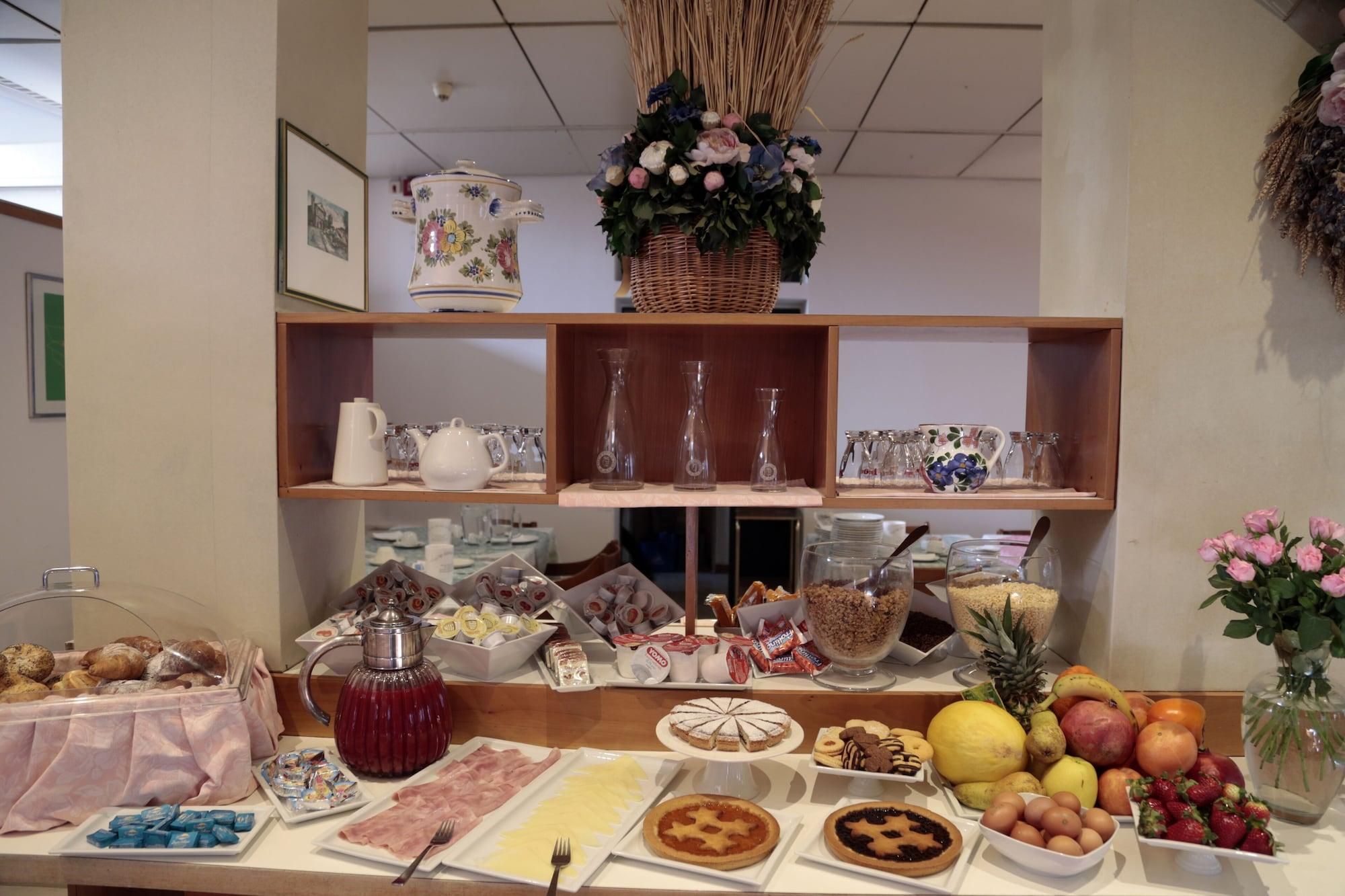 Un buffet proposant divers plats, un coin café et une sélection de verres présentés sur des étagères.