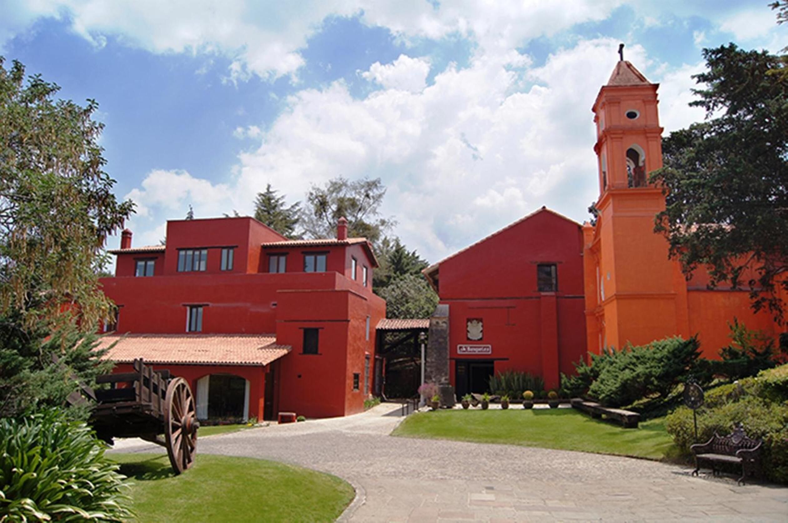 Un edificio rojo con una torre y un carruaje.