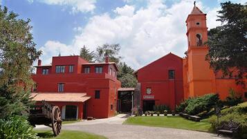 Un edificio rojo con una torre y un carruaje.