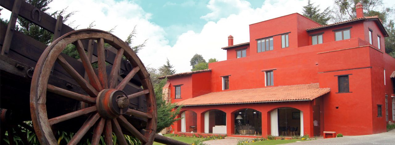 Un edificio rojo con una gran rueda de madera en su fachada.
