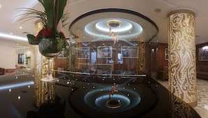 A lobby with a central chandelier, a glass barrier, and a decorative column. - Fredj Hotel (Tangier)
