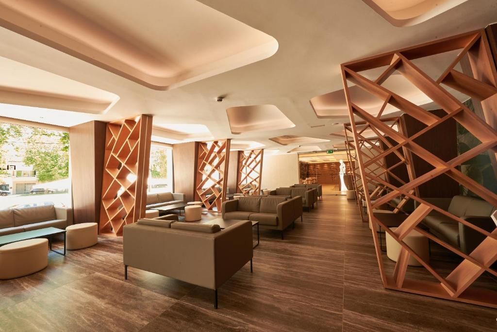 A modern lounge area with wooden partitions, comfortable seating, and a view of the outdoors.