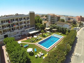 Un hotel con piscina, zona de estar al aire libre y vistas del entorno.