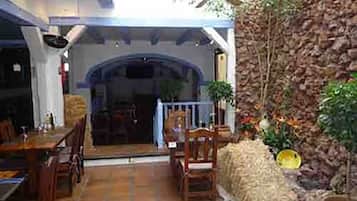 Un intérieur comprenant un coin repas, un mur en pierre et un ventilateur de plafond.