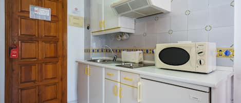 A kitchen with white cabinets, a microwave, and a sink.