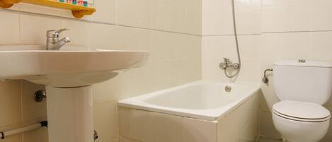 Une salle de bain avec un lavabo, une baignoire et des toilettes.