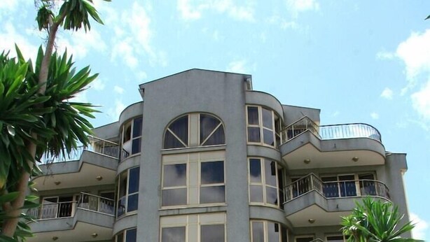 A multi-story building with balconies, large windows, and a gated entrance. - Weygoss Guest House (Addis Ababa)