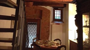 Un comedor con una mesa dispuesta para cuatro personas, una escalera y vistas del piso superior.