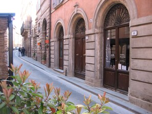 Une vue de rue avec un bâtiment doté de fenêtres en arc de cercle et d’une grande porte, ainsi qu’une enseigne indiquant qu’il s’agit d’un restaurant ou d’un café.