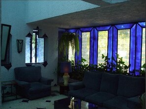 A room with a large window, a sofa, a lamp, and a plant. - Tarik (Tangier)