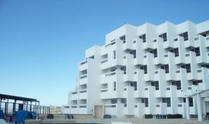 A modern multi-story building with a white facade and balconies. - Tarik (Tangier)