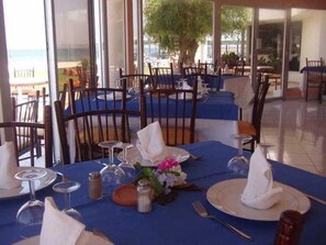 A restaurant with tables set for dining, featuring blue tablecloths and white napkins. - Tarik (Tangier)