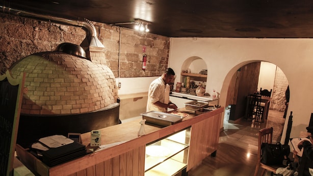 Een keuken met een bakoven, een houten aanrecht en een zithoek met een tafel en stoelen.