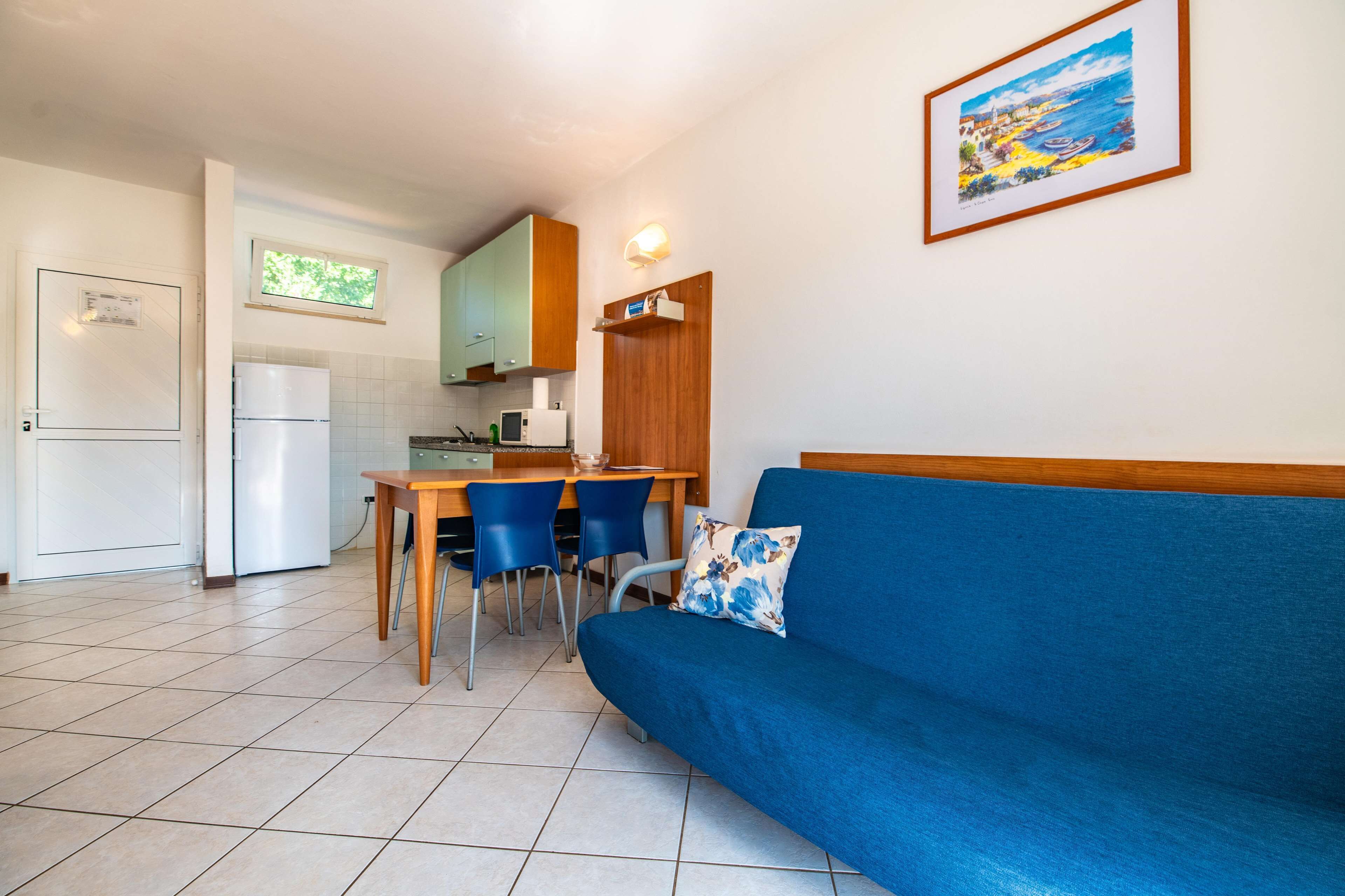 A compact living space with a kitchenette, a dining area, and a sofa.
