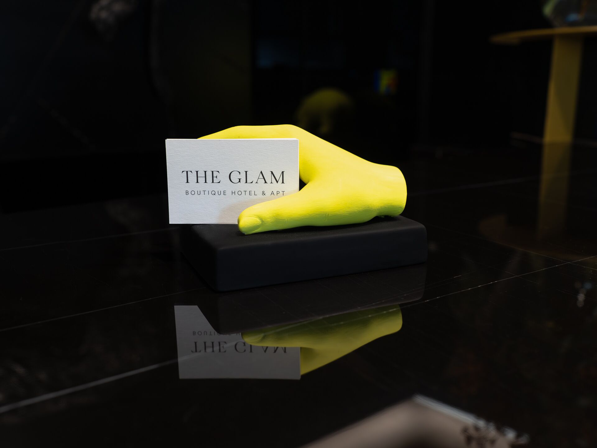 A yellow object on a black base with a sign that reads "THE GLAM BOUTIQUE HOTEL & APT".