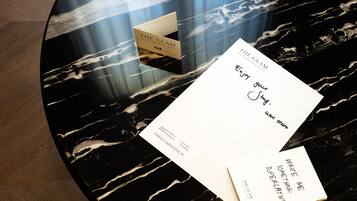 Una mesa de mármol negro con tres tarjetas de presentación y un folleto.