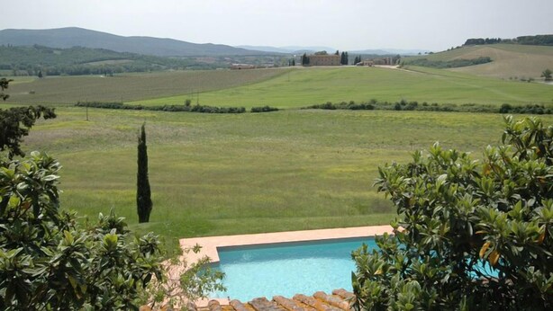 A pool with a view of a green field and distant hills. - Villa Sodi (Castellina in Chianti)