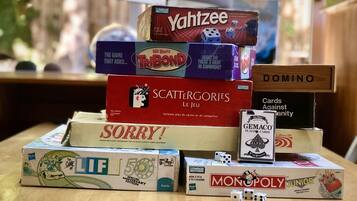 A variety of board games stacked on a table.