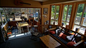 Une pièce chaleureuse avec une table en bois, un canapé et une guitare accrochée au mur.