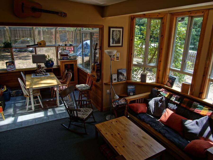 Una habitación acogedora con una mesa de madera, un sofá y una guitarra colgada en la pared.