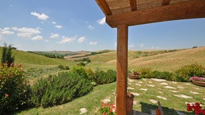 Una pérgola de madera con vistas a colinas onduladas y un cielo despejado.