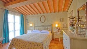 Une chambre à coucher comprenant un lit, des tables de chevet, une commode et un miroir.