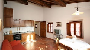 A spacious kitchen with wooden cabinets and a dining area with a table and chairs. - Certaldo (Certaldo)