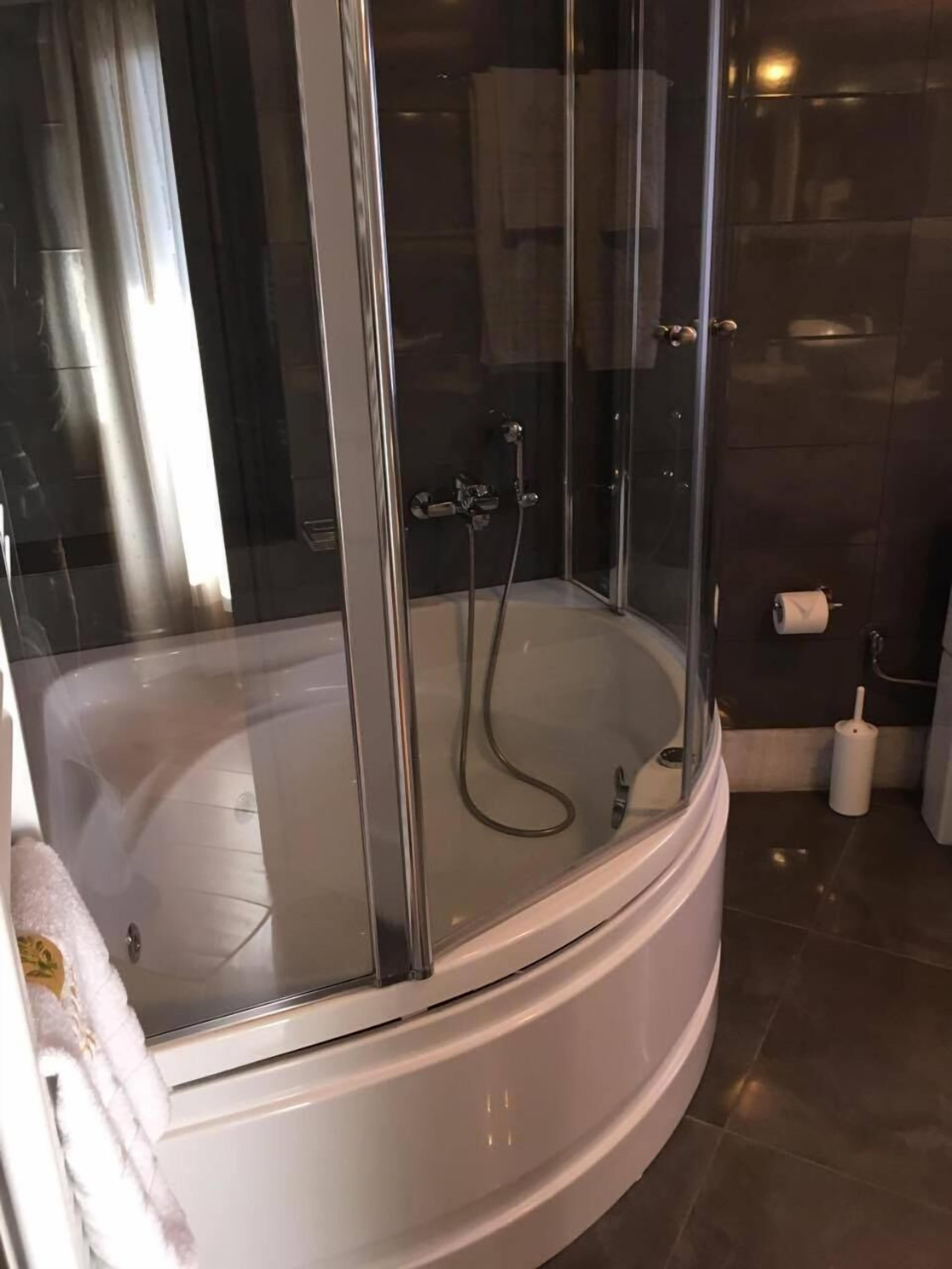 Une salle de bain moderne avec une douche à parois de verre, une baignoire blanche et des toilettes.