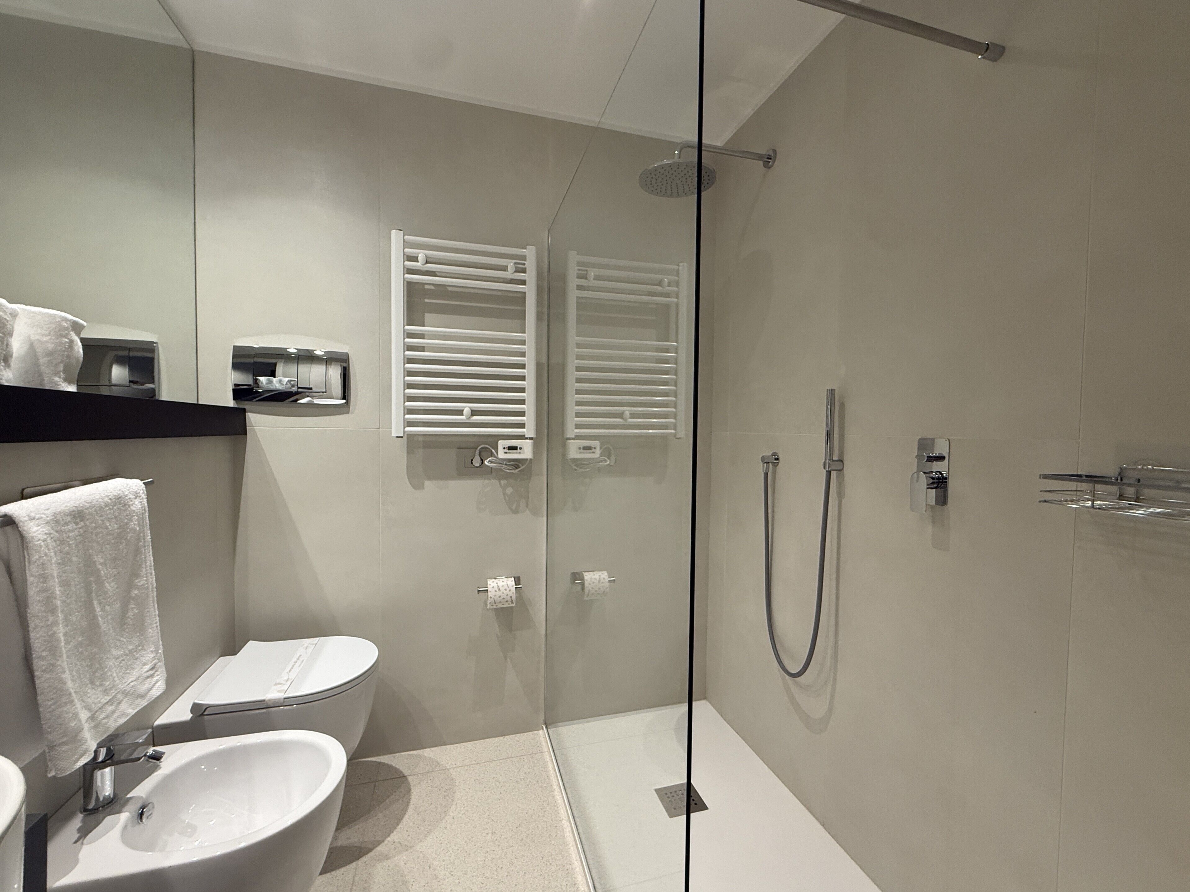 Ein modernes Badezimmer mit einer Duschkabine, einer Toilette und einem Waschbecken.