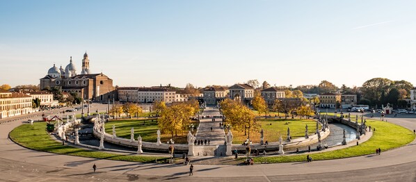 A large open square with a fountain, statues, and a historic building in the background. - Hotel Serafino  (Padova)