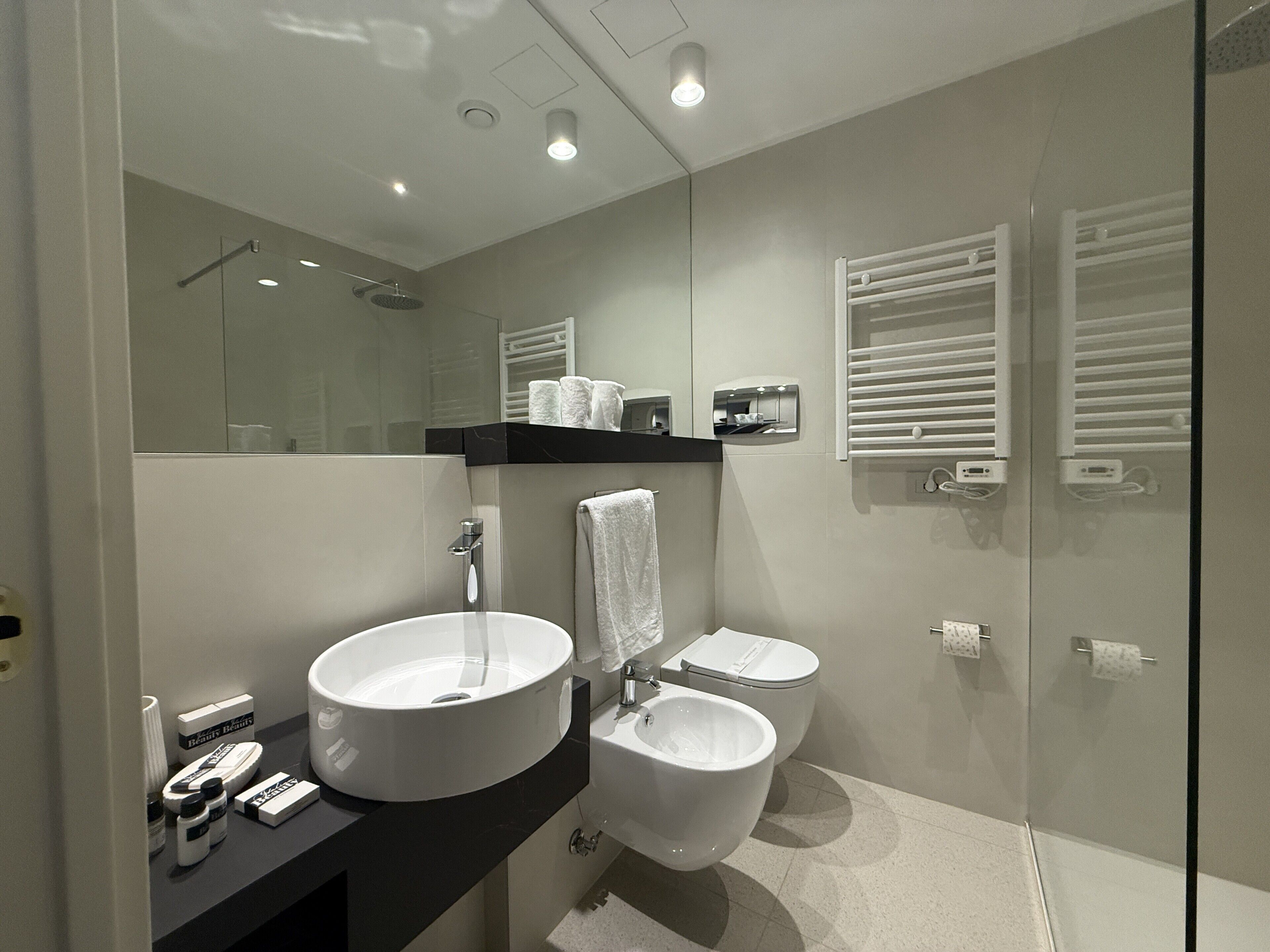 A modern bathroom with a large sink, toilet, and shower.