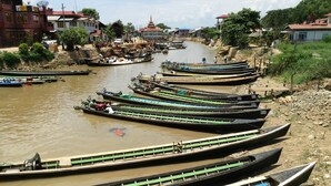 A river with several boats docked along the shore.