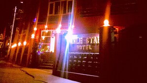 A hotel entrance at night with illuminated signage.