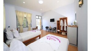Una habitación de hotel con dos camas, un escritorio, una silla, un televisor y un armario.