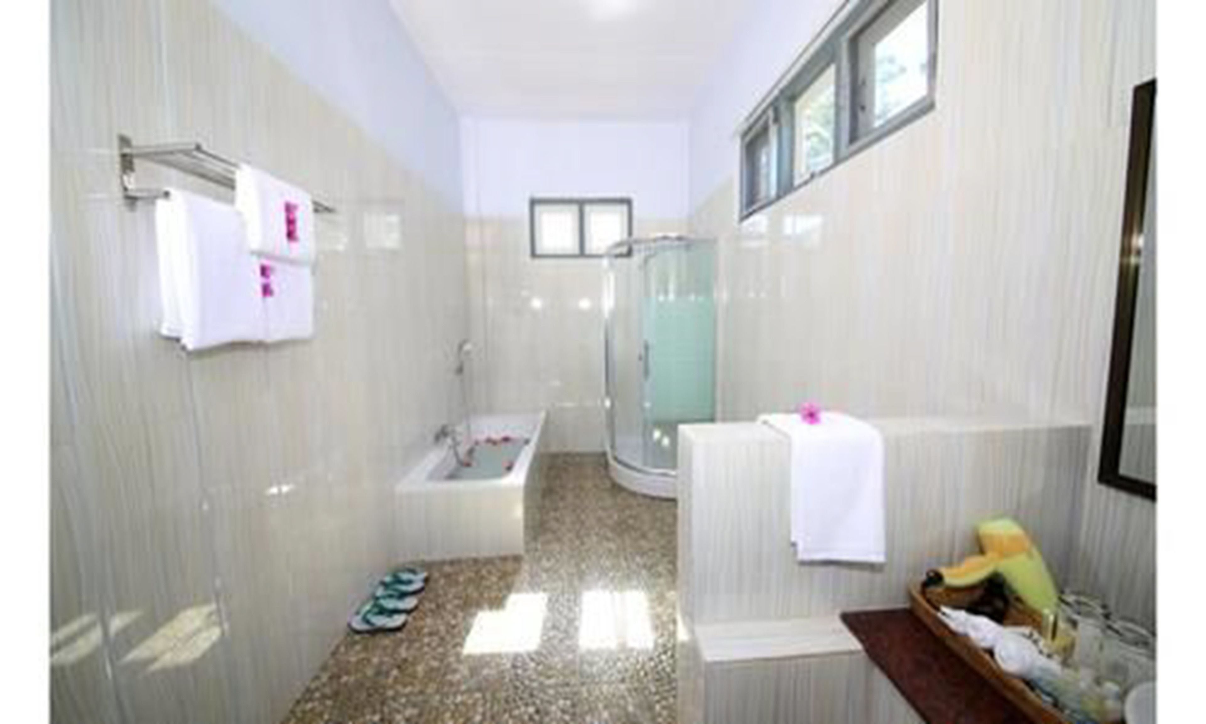 Un baño con ducha, bañera y lavamanos.