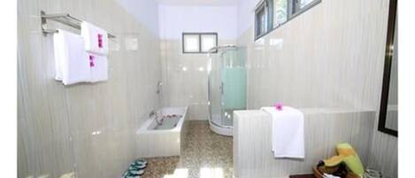 Un baño con ducha, bañera y lavamanos.