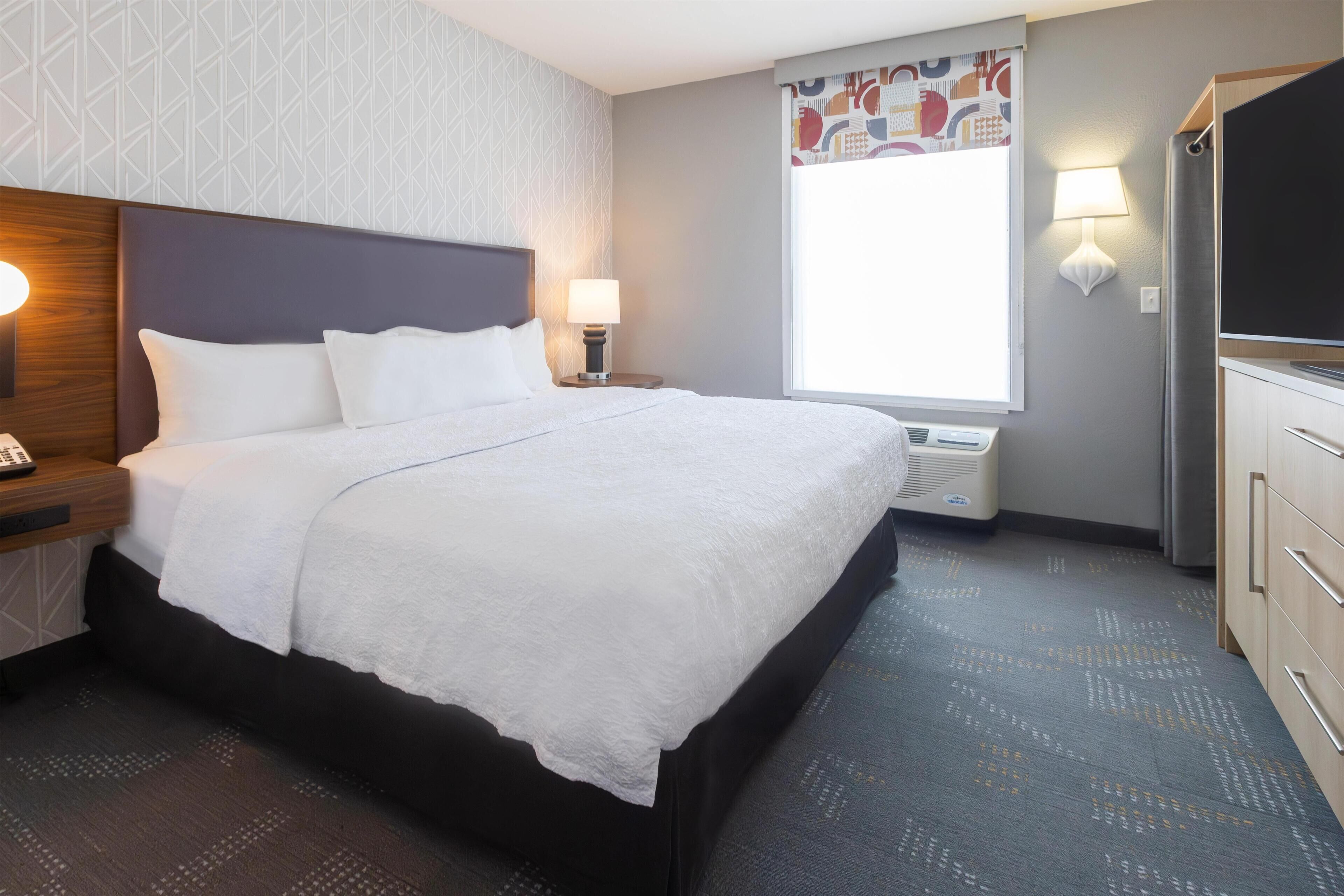 Premium bedding, desk, laptop workspace, blackout drapes