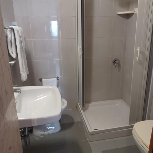 A bathroom with a shower, toilet, and sink. - Hotel Costa (Bari)