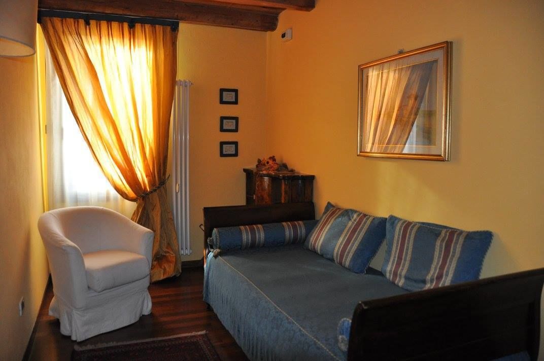 Una sala de estar acogedora con un sofá, un sillón y un cuadro en la pared.