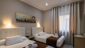 A hotel room with two beds, a painting on the wall, and a window with curtains. - Hotel Mexico (Madrid)